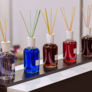 Aroma diffuser different colors in the store. Air fragrances in the form of liquid in glass bottles with a wooden sticks, on a table, at the exhibition.